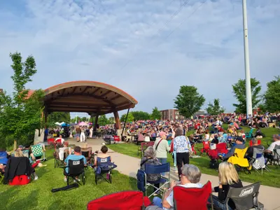 Music and Market Attendees sitting in lawn chairs at Levee Park